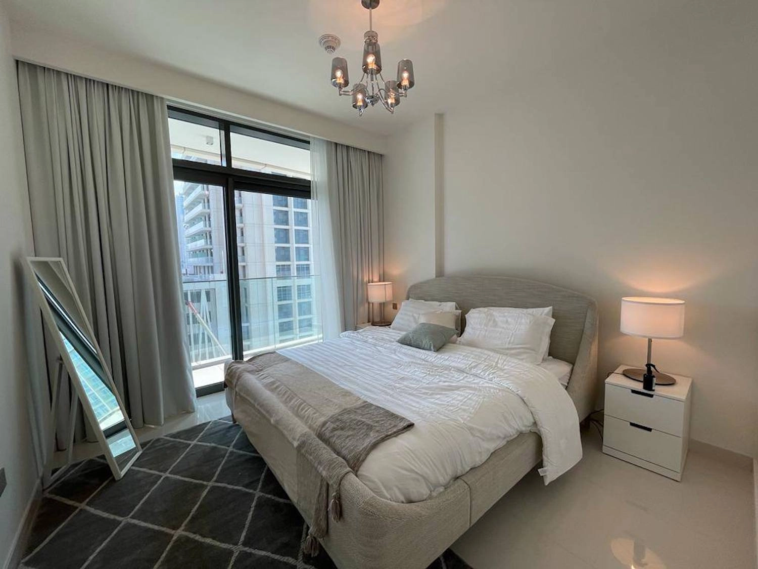 Bright 2 bedroom apartment bedroom with neutral finishes, soft lighting, and a balcony view.