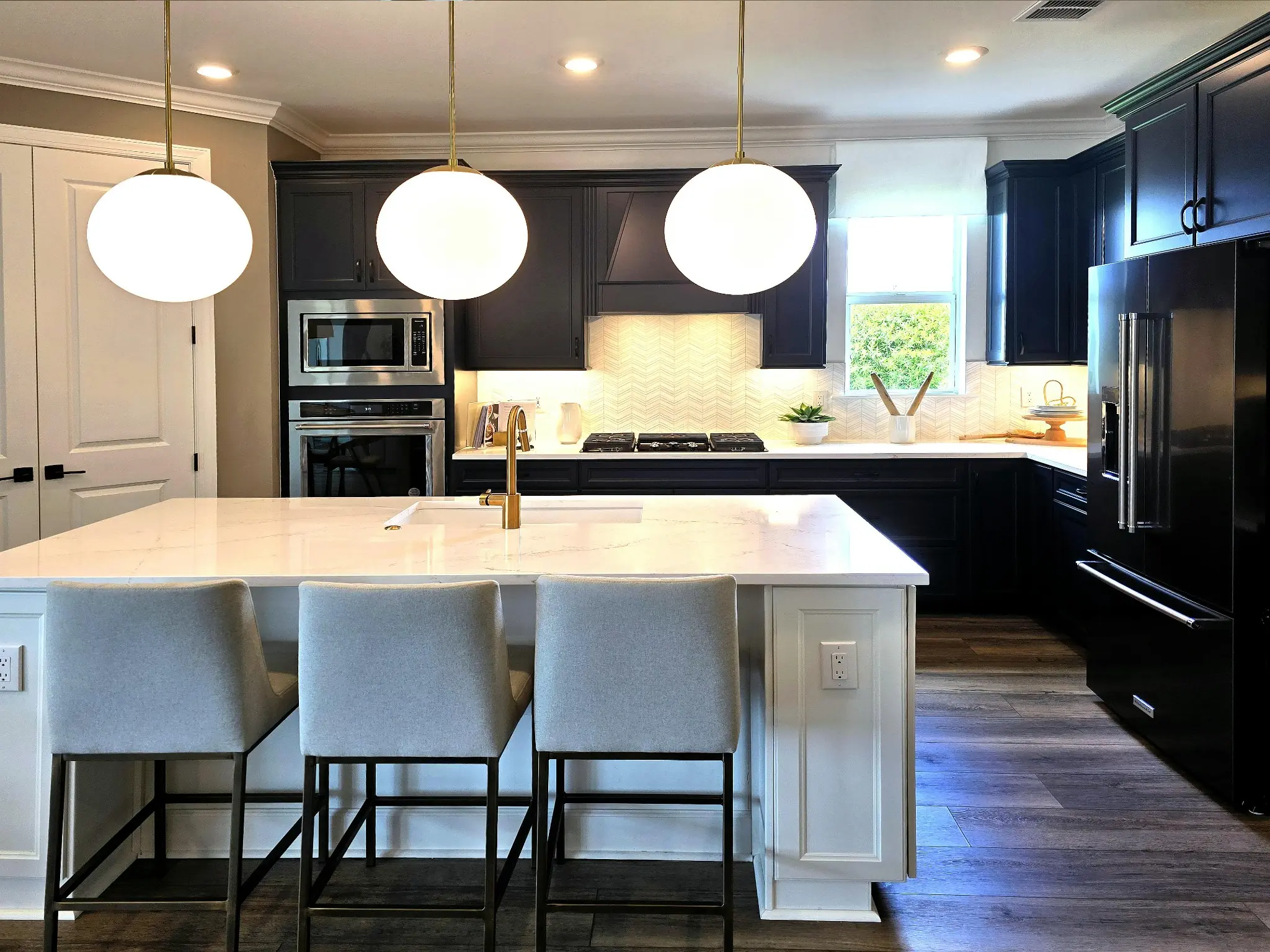 Kitchen renovation process in Dubai showing a modern island kitchen with pendant lights and clean finishes.