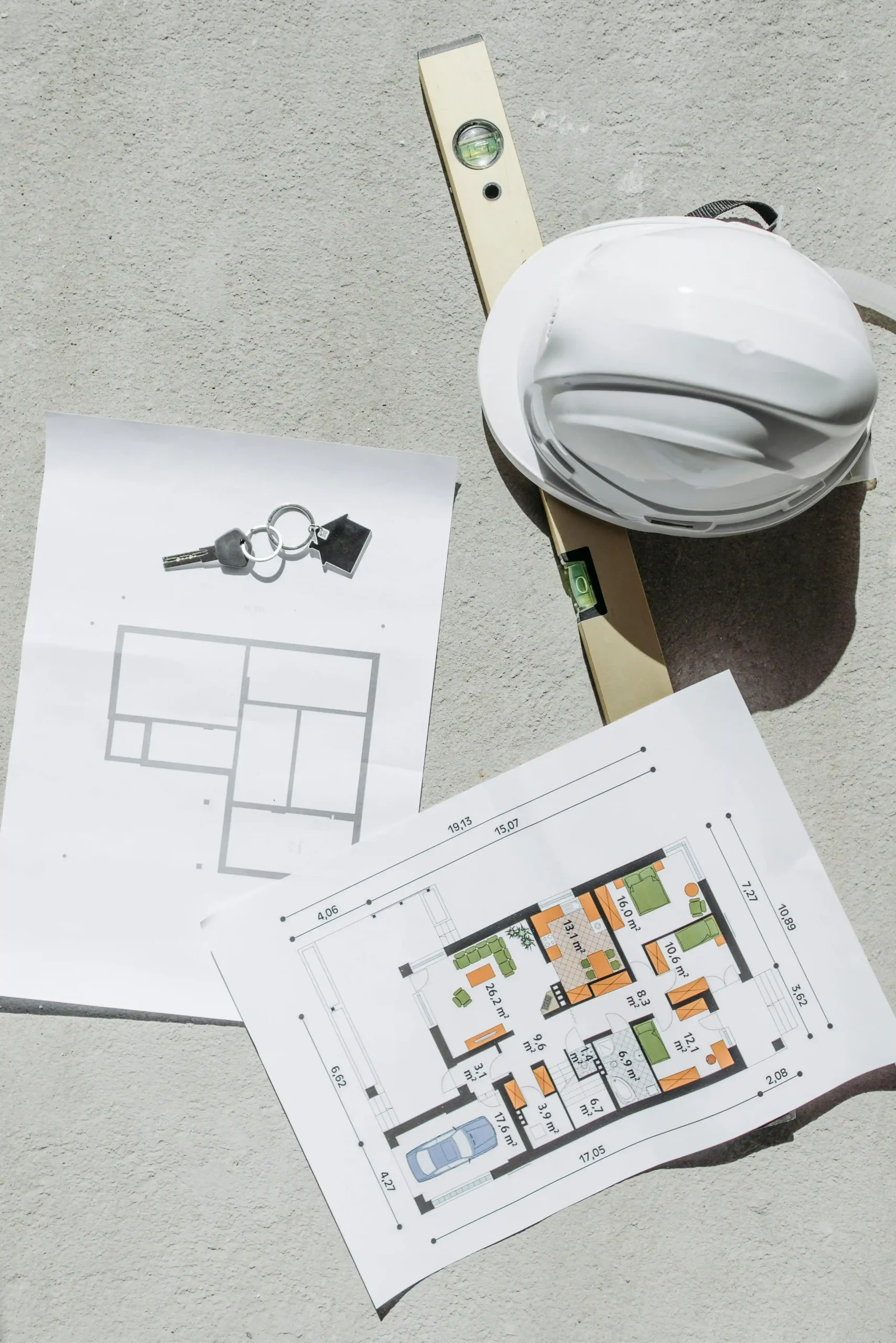 Fit out planning setup with floor plan drawings, site helmet, and measuring level for controlled execution
