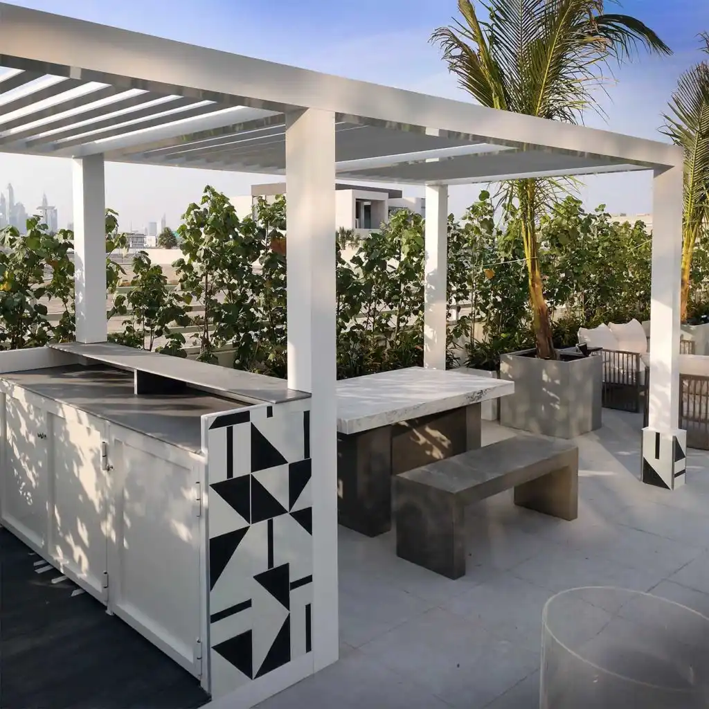 Modern aluminium pergola shading an outdoor kitchen and seating area on a Dubai rooftop terrace