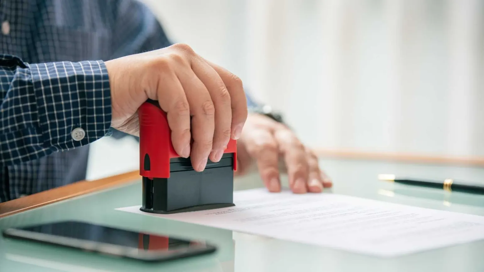 Hand stamping an approval document for Dubai developer NOC and building management NOC