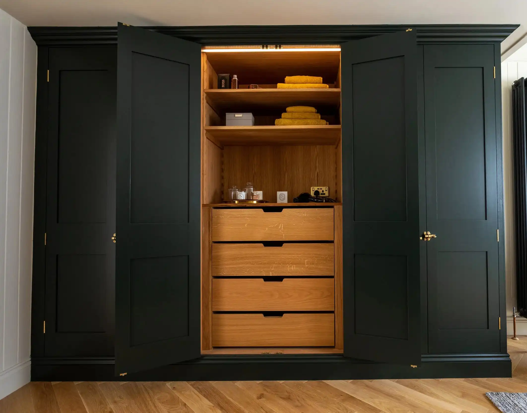 Custom wardrobe with full-height doors, internal drawers, and LED-lit shelving
