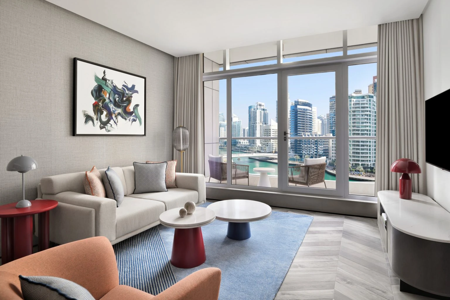 Residential turnkey apartment in Dubai Marina with a modern living room, neutral furniture, and floor-to-ceiling natural light.