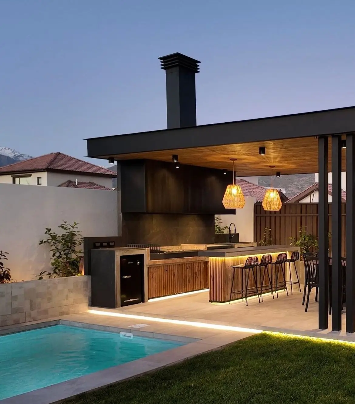 Outdoor pizza oven and specialty BBQ module with chimney and bar seating in a luxury Dubai villa