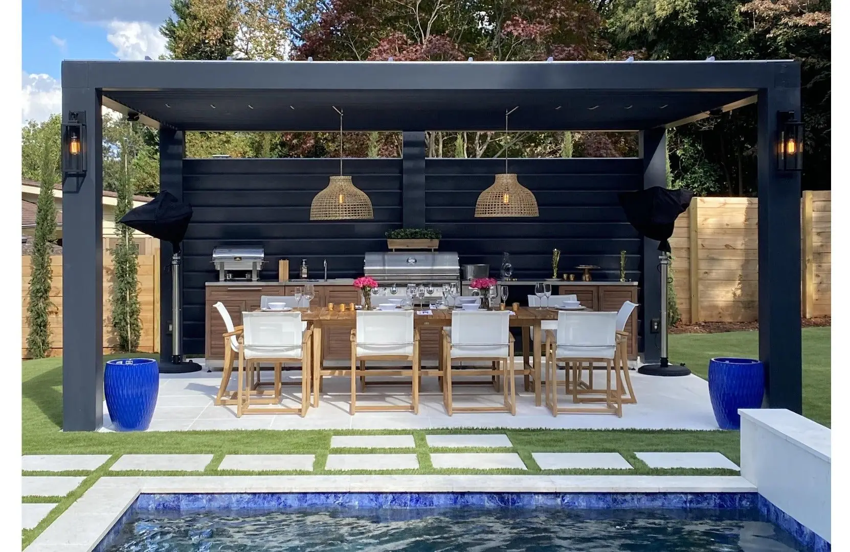 Outdoor kitchen BBQ installation process under pergola with dining setup and lighting in a Dubai villa